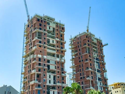 Construction progress of two residential towers under a bright blue sky in .. Foto stock