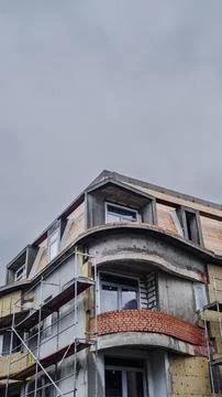 Construction Progresses on a Modern Building With Scaffolding at a Cloudy L.. Stock Photos