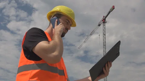 Construction project, engineer talking on phone, reading the plan, crane, site Stock Footage 39500548