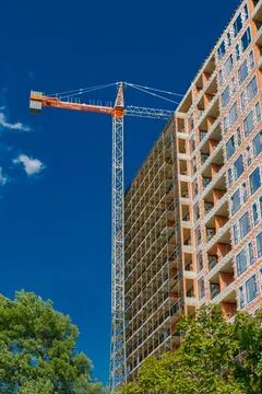 Construction project underway with crane lifting materials at a high-rise b.. Foto stock