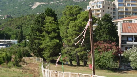 Construction red and white ribbon swings in the wind of the vegetable garden the Stock Footage 201547069