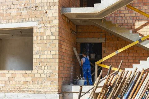 Construction of a red brick multi-storey building. Women workers Stock-Fotos