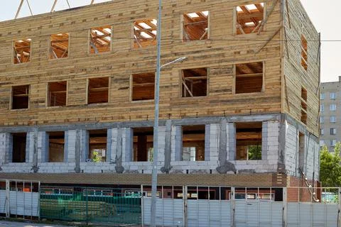 Construction of a residential building made of bricks and wooden logs without Stock Photos