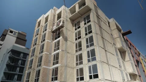 Construction of residential building made of white bricks. new houses, blue sky Stock Footage 163968100