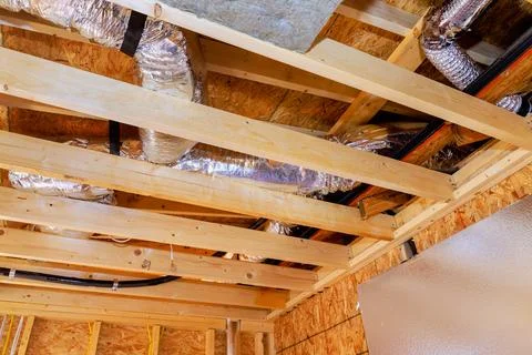 Construction of a residential ceiling with exposed ductwork and framing in a new 库存照片
