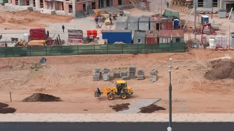Construction of a residential complex in the city, the tractor levels the ground Stock Footage 132333053