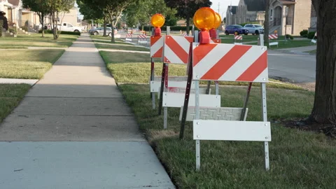 Construction road barricades with warning lights on a suburban sidewalk Stock Footage 338119764