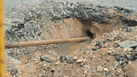 Construction on a road where a trench has been dug to install a pipe. The Video stock 344675371