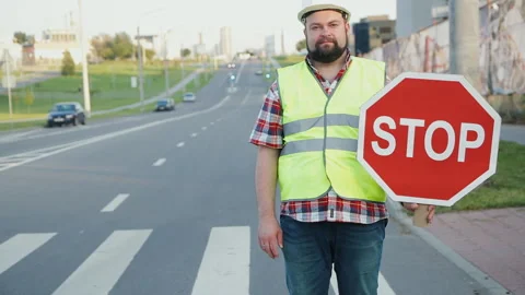 A construction road worker stopping traffic, holding a stop sign. Stock Footage 90844351