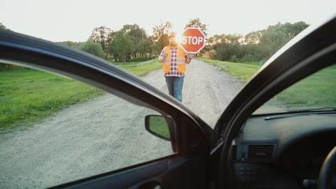 A construction road worker stopping traffic, holding a stop sign. View from the Video stock 90845092
