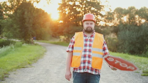 A construction road worker stopping traffic, holding a stop sign. Video stock 90845672