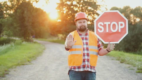 A construction road worker stopping traffic, holding a stop sign. Video stock 90845986