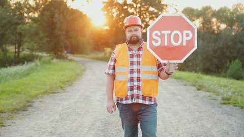 A construction road worker stopping traffic, holding a stop sign. Video stock 90846143