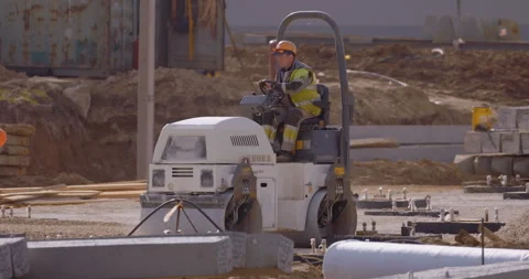 Construction roller compact the gravel base to further pave the area Stock Footage 147633567