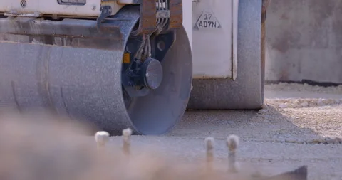 Construction roller compact the gravel base to further pave the area Stock Footage 147633630