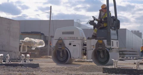 Construction roller compact the gravel base to further pave the area Stock Footage 161959621