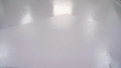 Construction roller in an empty room. The white floor is painted with a roller. Stock Photos