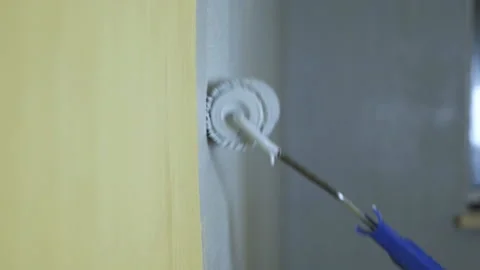 Construction roller paints the yellow wall with gray paint Video stock 123853931