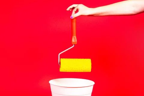 Construction roller is thrown into the trash on a red background Stock Photos