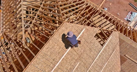 Construction roofer carpenter worker nailing wood plywood with roof installation Stock-Footage 197000025