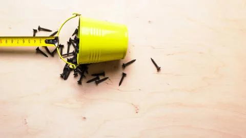 Construction roulette green pulls a bucket of screws on the background of woo Stock Photos