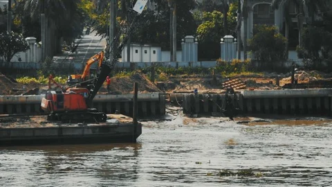 Construction on Saigon river using crane to scoop the sand into the river 스톡 동영상 105871295