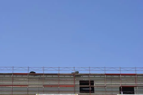 Construction Scaffolding on Building Facade Under Blue Sky Stock Photos