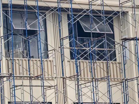 Construction scaffolding structure on building facade with geometric metal f Fotos Stock
