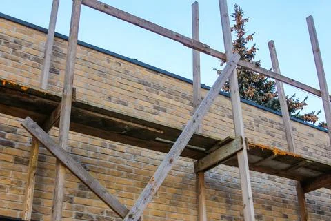 Construction scaffolding supporting renovation work on a brick wall Stock Photos
