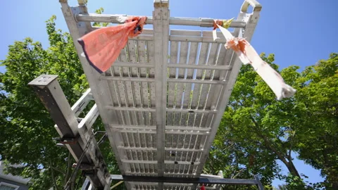 Construction scaffolding viewed from below, showing the metal platform with Stock Footage 318497565