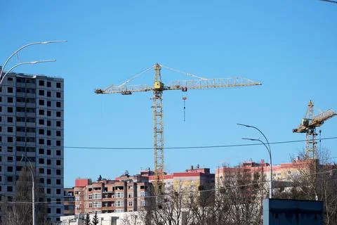 Construction scene with cranes against a clear blue sky Stock Photos