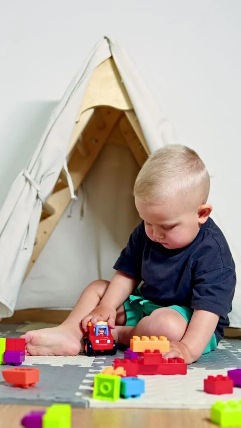 A construction set for developing a childs hand motor skills. A 2-year-old boy Stock Footage 319936807