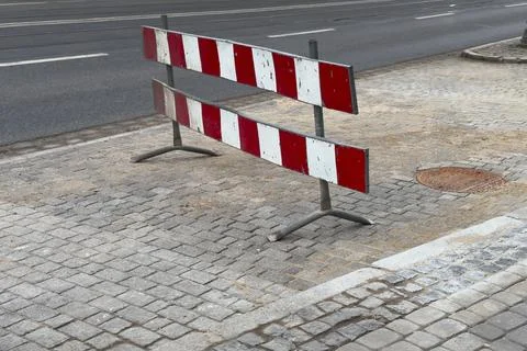 Construction Sign Blocks Path Along City Street Near Sidewalk at Midday Dur.. Stock Photos