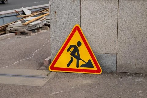 Construction sign placed on the bridge warns pedestrians of ongoing work Stock Photos