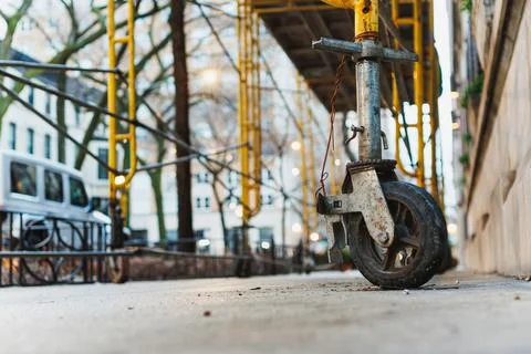 A construction site is active on a city sidewalk. Workers use various tools a 写真素材