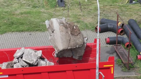 Construction site activity with heavy equipment transporting large concrete Видео 347580477