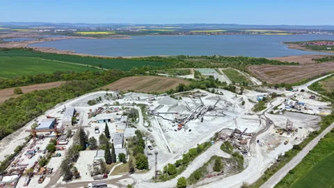 Construction site activity at a mining extraction location by a river in Stock Footage 340165210