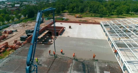 Construction site from the air. workers are pouring concrete over the floor of Видео 168219148