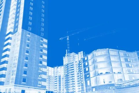 Construction site background. Hoisting cranes and new multi-storey buildings. Stock Photos