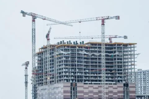 Construction site background. Hoisting cranes and new multi-storey buildings Stock Photos