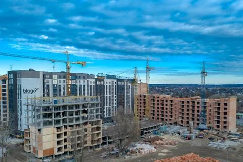 Construction site background. Hoisting cranes and new multi-storey buildings. Stock Photos