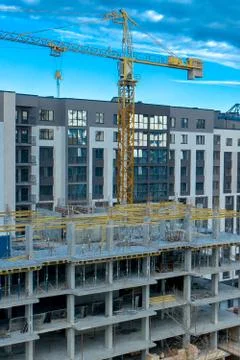 Construction site background. Hoisting cranes and new multi-storey buildings. Stock Photos