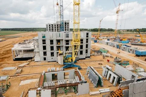 Construction site background. Hoisting cranes and new multi-storey buildings Stock Photos