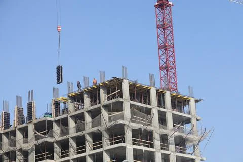 Construction site background. Hoisting cranes and new multi-storey building.. Stock Photos