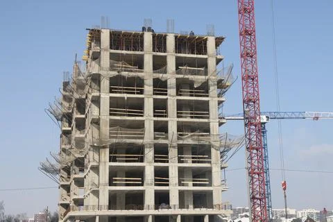 Construction site background. Hoisting cranes and new multi-storey building.. Stock Photos