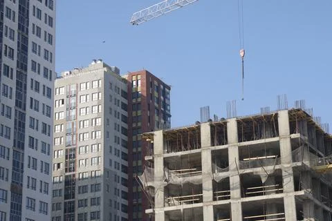 Construction site background. Hoisting cranes and new multi-storey building.. Stock Photos