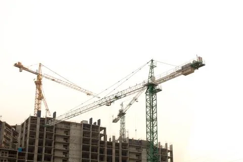 Construction site background. Hoisting cranes and new multi-storey building.. Stock Photos