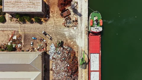 Construction site with a barge loading cargo by the waterfront in a busy 스톡 동영상 340770766