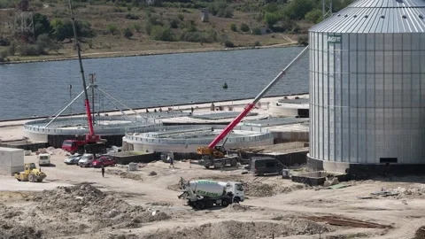 Construction site building agricultural grain silos near a river Stock Footage 345928225