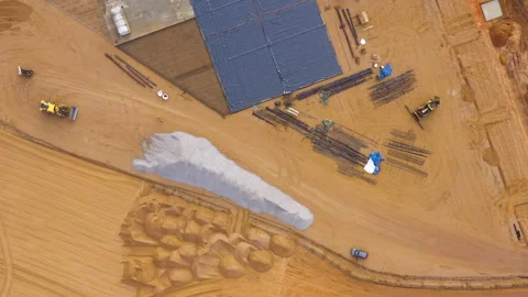 Construction site with building foundation, stacked materials, and heavy Stock Footage 297469632